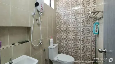 a small bathroom with a toilet and a shower at Jemput Rezeki Homestay in Bayan Lepas