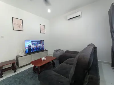 a living room with a couch and a tv at Jemput Rezeki Homestay in Bayan Lepas