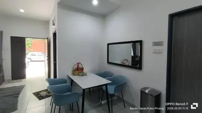 a dining room with a table and blue chairs at Jemput Rezeki Homestay in Bayan Lepas