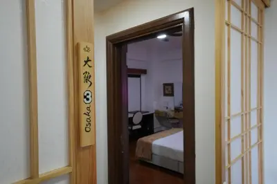a door to a room with a bed and a mirror at Japan Comfort Lifestyle Osaka in Ipoh