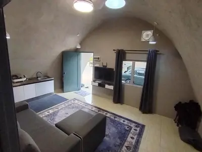 a living room with a couch and a tv at Dome Glamping Lojing Highlands in Ladang Pangoi