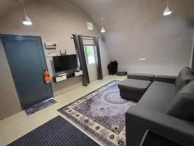 a living room with a couch and a tv at Dome Glamping Lojing Highlands in Ladang Pangoi