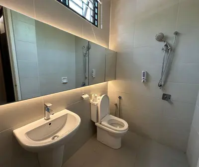a bathroom with a toilet and a sink and a mirror at Luxury 5BR stay walk to beach & Night market fun in Batu Ferringhi