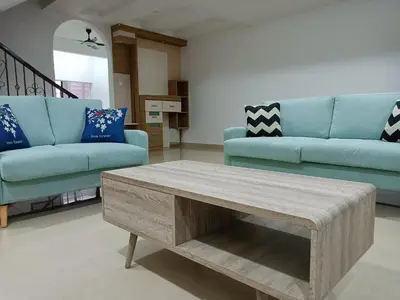 a living room with a blue couch and a coffee table at 28 Home in Pusing