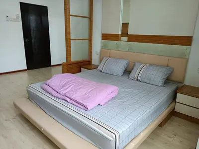a bed with a purple blanket on top of it at 28 Home in Pusing