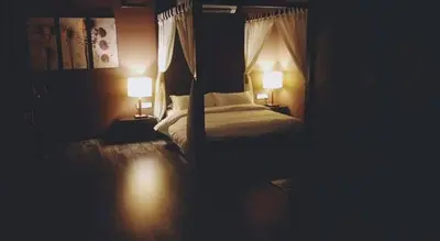 a dark room with a bed with two lamps at 30A Studio Room Medan Ipoh with Pool Table in Ipoh