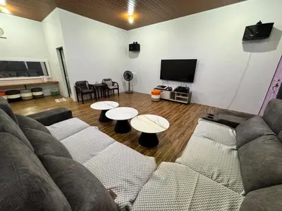 a living room with a couch and two tables at Olly de Home Ent in Batu Gajah