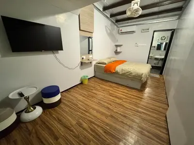 a bedroom with a bed and a flat screen tv at Olly de Home Ent in Batu Gajah