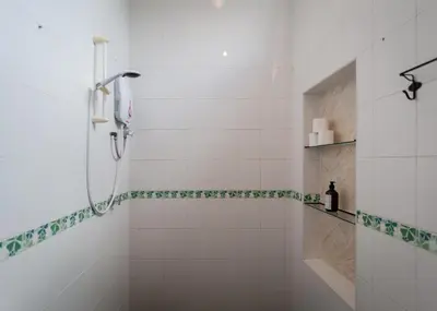 a bathroom with a shower with green and white tiles at Aayu Church St - 7 mins to Esplanade, George Town in George Town