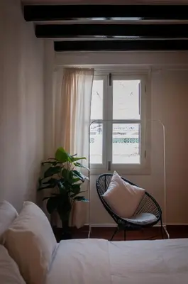 a bedroom with a bed and a chair and a window at Aayu Church St - 7 mins to Esplanade, George Town in George Town