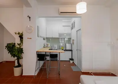 a kitchen with white cabinets and a wooden counter top at Aayu Church St - 7 mins to Esplanade, George Town in George Town
