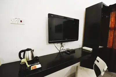 a black desk with a television on a wall at AZYA Hotel in TanjongMalim