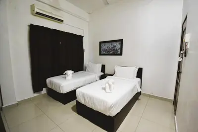a hotel room with two beds with white sheets at AZYA Hotel in TanjongMalim