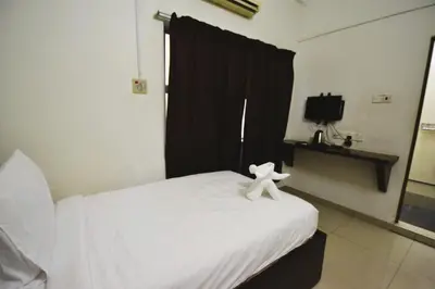 a white teddy bear sitting on top of a bed at AZYA Hotel in TanjongMalim