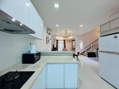 a large kitchen with white cabinets and a staircase at Shamrock Bay Haven 5BR Homestay for 22pax at B Ferringghi in Batu Ferringhi