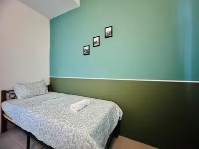 a bedroom with a bed and a blue wall at Shamrock Bay Haven 5BR Homestay for 22pax at B Ferringghi in Batu Ferringhi