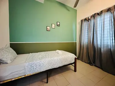 a bedroom with a bed and a green wall at Shamrock Bay Haven 5BR Homestay for 22pax at B Ferringghi in Batu Ferringhi