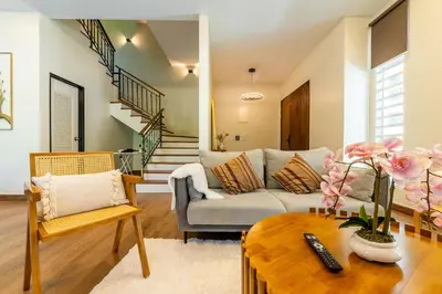 a living room with a couch and a table at La Ferringhi Villa - Tropical Collection, by ALV in Batu Ferringhi