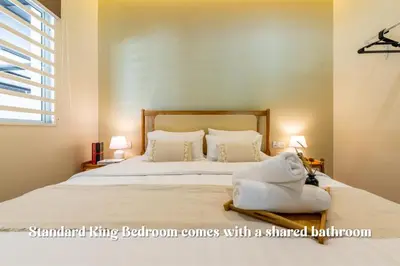 a bedroom with a large bed with a shared bathroom at La Ferringhi Villa - Tropical Collection, by ALV in Batu Ferringhi