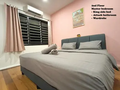 a bedroom with a large bed with a cat laying on it at Fair Park 2 at Ipoh Town Center in Ipoh