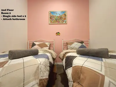 a bedroom with two beds and a painting on the wall at Fair Park 2 at Ipoh Town Center in Ipoh