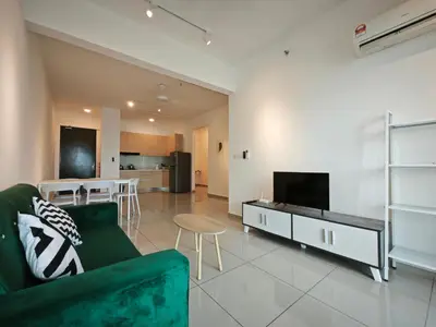 a living room with a green couch and a television at Metropol Serviced Apartment - Bukit Mertajam, Penang in Bukit Mertajam