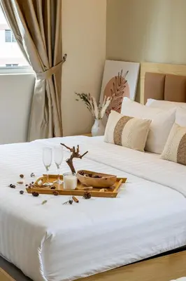 two beds with a tray with wine glasses on it at La Ferringhi Villa - Ryokan Collection, by ALV in Batu Ferringhi