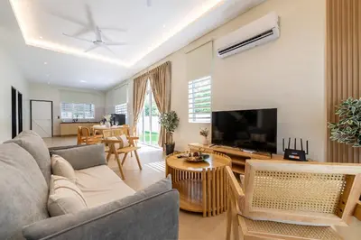 a living room with a couch and a flat screen tv at La Ferringhi Villa - Ryokan Collection, by ALV in Batu Ferringhi
