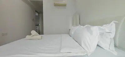 a white bed with white pillows and a stuffed animal on it at Island Jazz Loft with Bathtub & Seaview - Jazz Suites by Ocean Luxe in Tanjong Tokong