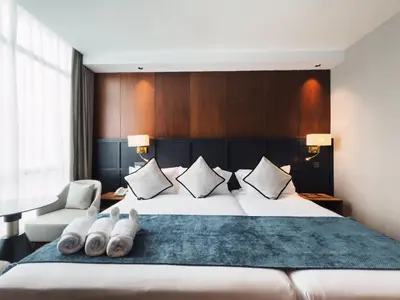 a hotel room with a large bed with two pairs of towels at Moon Hotel in George Town