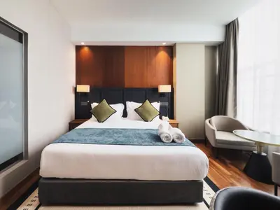 a hotel room with a bed with a teddy bear on it at Moon Hotel in George Town