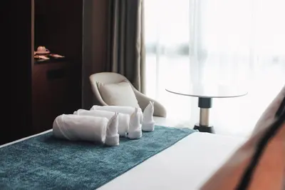 a hotel room with a pile of towels on a bed at Moon Hotel in George Town