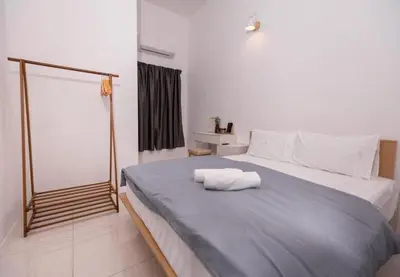 a bedroom with a bed with two towels on it at Taiping Bali Home 5R3B, 7mins-Tpg Lake Gardens in Taiping