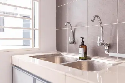 a kitchen sink with a bottle of wine on it at Taiping Bali Home 5R3B, 7mins-Tpg Lake Gardens in Taiping