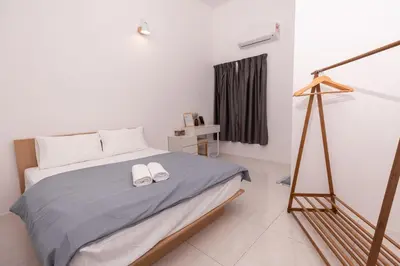 a bedroom with a bed with two white shoes on it at Taiping Bali Home 5R3B, 7mins-Tpg Lake Gardens in Taiping