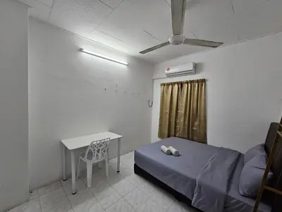 a room with a bed and a table and a desk at Double S Hostel in Ipoh