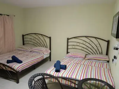 two beds with blue bows on them in a bedroom at Ali's Guest House in Batu Ferringhi
