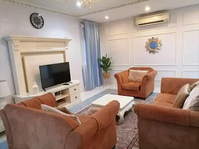 a living room with couches and a flat screen tv at Anandavilla in Seri Manjung