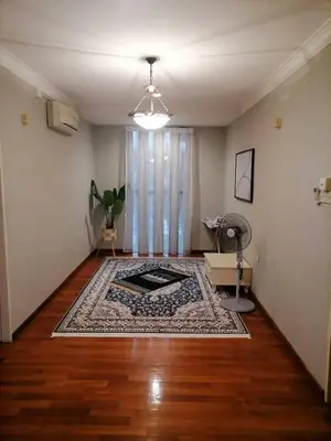 a living room with a rug on a wooden floor at Anandavilla in Seri Manjung