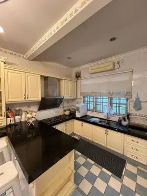 a kitchen with white cabinets and a black counter top at Anandavilla in Seri Manjung