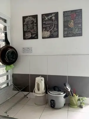 a bathroom with a toilet and posters on the wall at CAMERON LADY ANI Homestay in Tanah Rata