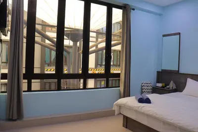 a bedroom with a bed and a large window at Hotel Aaraa in Brinchang