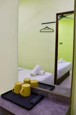 a tray with two yellow cups and a mirror at Hotel Aaraa in Brinchang