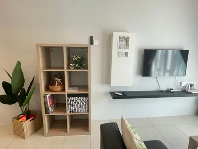 a living room with a tv and a shelf at Ipoh The Anderson 5pax Suite #82 in Ipoh