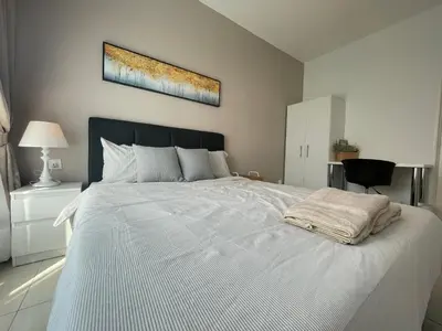 a bedroom with a large white bed with a blanket at Ipoh The Anderson 5pax Suite #82 in Ipoh