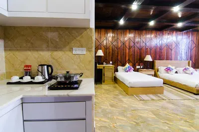 a kitchen with two beds in a room with a stove at Mornington Hotel Sitiawan in Sitiawan