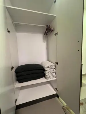 a closet with white walls and white shelves with towels at Shahiqa Homestay Cameron Highland in Brinchang