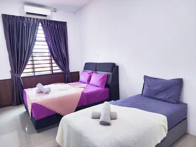 a bedroom with two beds and a window at 30 Bercham Double-Storey Homestay in Ipoh