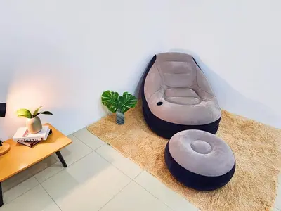 a living room with a ottoman sitting on the floor at 30 Bercham Double-Storey Homestay in Ipoh