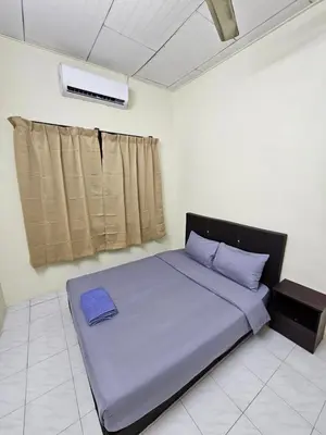 a bedroom with a large bed with blue sheets and a window at May Flower Hostel in Ipoh